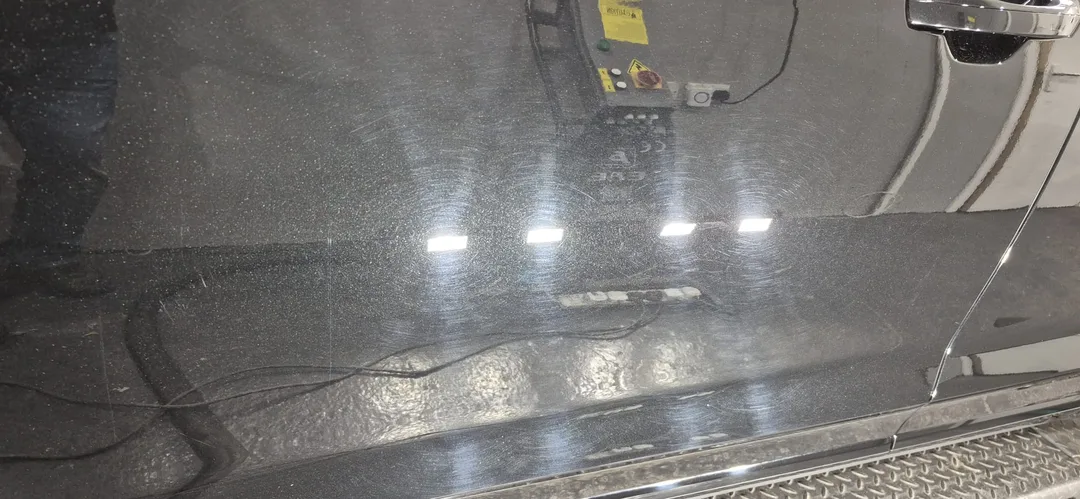 Close-up of swirl marks on the Mythos Black Metallic paintwork on door panel